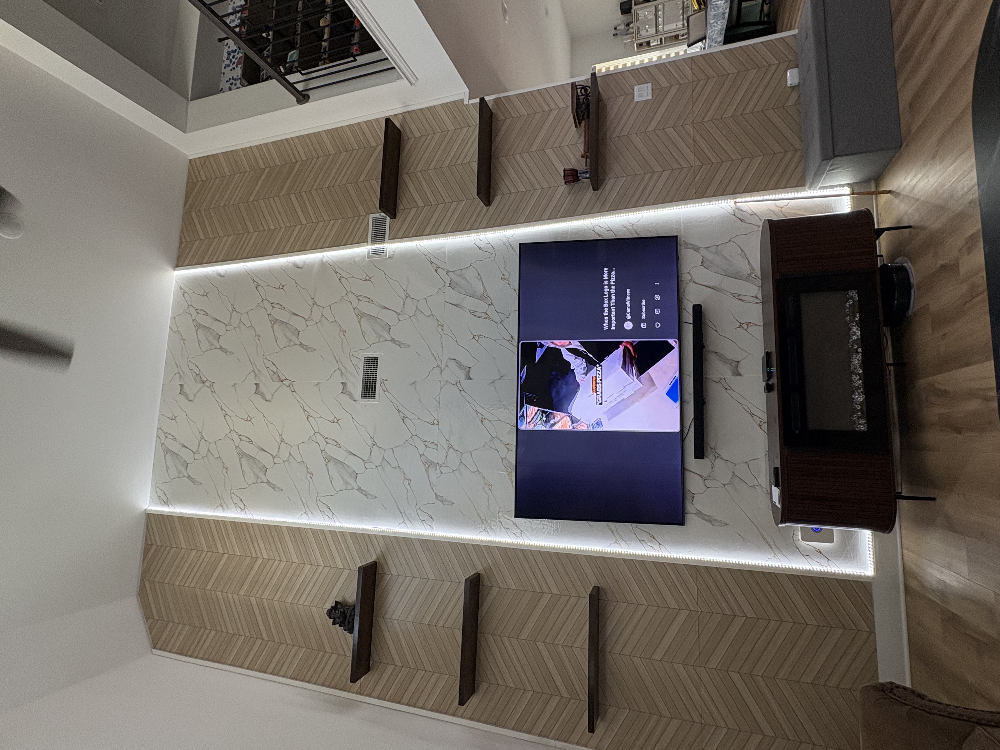 Finished chevron accent wall with marble panel and floating shelves